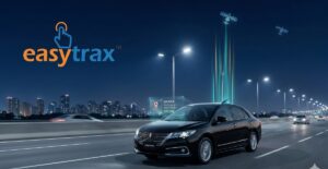 A black sedan drives on a highway at night with city lights in the background. Digital graphics display GPS signals, a location pin, and a GPS Tracking Device icon. The easytrax logo appears in the top left, indicating GPS tracking services.